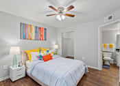 Thumbnail 25 of 38 - A bedroom with a bed, nightstand, and a painting on the wall.