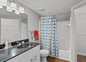 Thumbnail 24 of 38 - A bathroom with a black counter top and a white toilet.