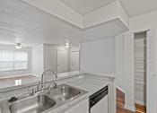 Thumbnail 20 of 23 - A kitchen with a sink, dishwasher, and a window.