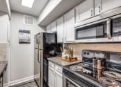 Thumbnail 5 of 20 - an updated kitchen with stainless steel appliances and white cabinets