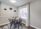 Thumbnail 10 of 20 - a dining room with a table and chairs and a window