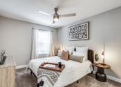 Thumbnail 6 of 20 - a bedroom with a bed and a ceiling fan