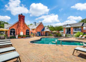 Thumbnail 9 of 20 - a swimming pool in front of a brick house with a pool