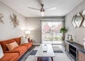 Thumbnail 1 of 20 - a living room with a orange couch and a sliding glass door