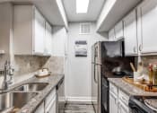 Thumbnail 3 of 20 - a kitchen with stainless steel appliances and granite counter tops