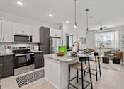 Thumbnail 20 of 40 - A modern kitchen with a large island and bar stools.