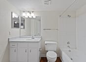 Thumbnail 18 of 23 - A white bathroom with a sink, toilet, and bathtub.