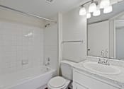 Thumbnail 19 of 23 - A white bathroom with a toilet, sink, and bathtub.