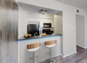 Thumbnail 12 of 18 - a kitchen with a counter with two stools