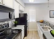 Thumbnail 11 of 18 - a kitchen with stainless steel appliances and a sink and a refrigerator
