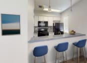 Thumbnail 7 of 18 - a kitchen with a counter top and three stools