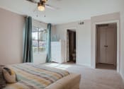Thumbnail 8 of 20 - a bedroom with a bed and a closet and a ceiling fan
