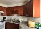 Thumbnail 12 of 13 - a kitchen with wood cabinets and granite countertops