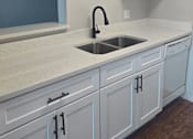 Thumbnail 21 of 33 - an empty kitchen with white cabinets and a sink