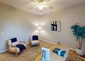 Thumbnail 6 of 26 - a living room with a ceiling fan and two chairs