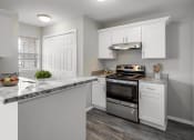 Thumbnail 2 of 13 - a kitchen with white cabinets and stainless steel appliances and a marble counter top