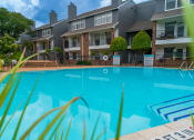 Thumbnail 34 of 37 - the view of a swimming pool with an apartment building in the background