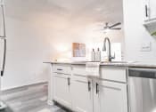 Thumbnail 15 of 37 - a view of a kitchen with white cabinets and a ceiling fan