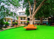 Thumbnail 20 of 37 - a large yard with a wooden picnic bench in front of a tree