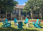 Thumbnail 12 of 33 - an outdoor lounge area with chairs and trees in front of an apartment building