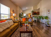 Thumbnail 5 of 9 - A living room with a brown sofa and a wooden coffee table.