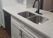 Thumbnail 16 of 33 - an empty kitchen with white cabinets and a sink
