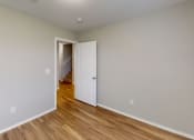 Thumbnail 18 of 20 - an empty room with wood floors and a white door