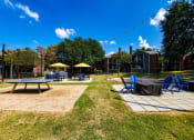 Thumbnail 17 of 23 - a patio with tables and chairs and umbrellas in a park