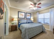 Thumbnail 3 of 25 - a bedroom with a bed and a ceiling fan