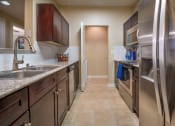 Thumbnail 9 of 25 - a kitchen with stainless steel appliances and granite counter tops