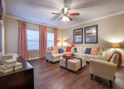 Thumbnail 1 of 25 - a living room with couches and chairs and a ceiling fan