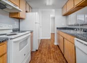 Thumbnail 14 of 35 - an empty kitchen with white appliances and wood cabinets