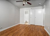 Thumbnail 15 of 35 - an empty living room with wood flooring and a ceiling fan