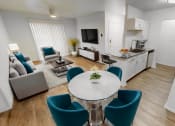 Thumbnail 1 of 23 - Modern open-plan living room and kitchen in an east riverside apartment with stylish decor, including a round table with teal chairs, beige sofa, and wooden flooring.