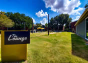 Thumbnail 19 of 23 - a yard with a sign for the lounge in front of a building