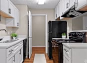 Thumbnail 7 of 16 - a kitchen with white cabinets and a black stove and refrigerator