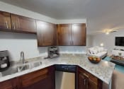 Thumbnail 4 of 13 - a kitchen and living room with a granite counter top