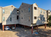 Thumbnail 8 of 8 - a building with a brick facade and a parking lot with cars