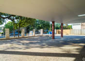Thumbnail 7 of 8 - a covered parking lot with a fence and trees