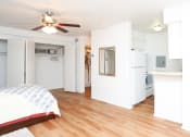 Thumbnail 16 of 16 - a bedroom with a bed and a kitchen with a ceiling fan