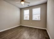 Thumbnail 7 of 27 - an empty room with a ceiling fan and three windows
