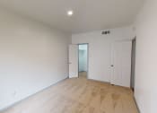 Thumbnail 1 of 43 - a living room with white walls and a door to a hallway