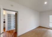 Thumbnail 6 of 43 - a living room with white walls and a door to a closet