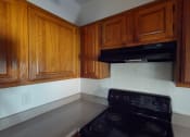 Thumbnail 23 of 43 - a kitchen with wooden cabinets and a stove and a black oven