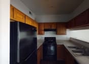 Thumbnail 18 of 43 - a kitchen with black appliances and wooden cabinets
