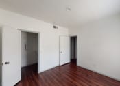 Thumbnail 15 of 43 - a bedroom with white walls and wood floors and a closet