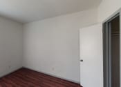 Thumbnail 17 of 43 - a bedroom with white walls and wood flooring and a window