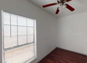 Thumbnail 13 of 43 - an empty bedroom with a large window and a ceiling fan