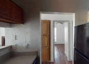 Thumbnail 22 of 43 - a kitchen with a refrigerator and a door to a hallway