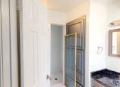 Thumbnail 38 of 43 - a bathroom with a white door and a sink and a mirror